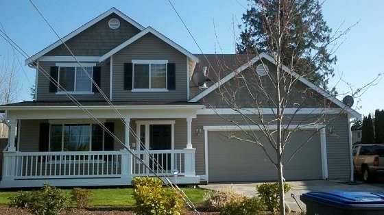 Freshly painted gray two-story home with white porch trim and dark shutters